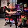 A man is playing a video game on a computer, sitting in a gaming chair. Produktbild-Vorschau