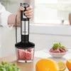 A person is using a hand blender to chop food in a kitchen setting. Anteprima dell’immagine prodotto