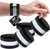 A hand wearing a reflective wristband, with several other reflective wristbands arranged in the foreground. Anteprima dell’immagine prodotto