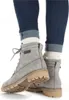 A close-up shot of a person wearing grey lace-up boots and blue jeans. Anteprima dell’immagine prodotto