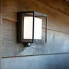 A modern outdoor wall light mounted on a wooden wall. Anteprima dell’immagine prodotto