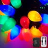 A close-up of colorful LED Christmas lights with a battery pack and remote control. Produktbild-Vorschau