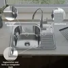 A stainless steel kitchen sink with a faucet and drainboard, shown with callouts highlighting its features. Produktbild-Vorschau