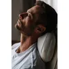 A man is resting his head on a massage pillow. Produktbild-Vorschau