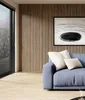 A modern living room with a blue sofa, wooden wall panels, and a large window with blinds. Náhľad obrázku produktu