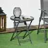 A small round folding table with a glass top, a candle lantern, and a book on a patio with artificial grass and wooden decking. Produktbild-Vorschau