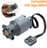 A hand holding a Lego motor with a cable and connector, with another motor in the foreground. Produktbild-Vorschau