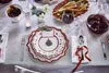 A festive Christmas table setting with plates, cutlery, wine, and food. Náhled obrázku produktu