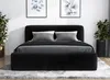 A black upholstered bed frame with gray bedding and pillows, set against a white wall with framed artwork and potted plants. Produktbild-Vorschau