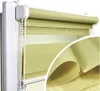 A close-up view of a green roller blind with a white pull cord, mounted on a white window frame. A magnified section of the fabric is shown in the lower right corner. Produktbild-Vorschau