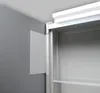 A close-up view of a cabinet hinge and a wall-mounted panel next to a cabinet interior. Náhľad obrázku produktu