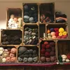 A collection of wooden crates filled with various types of yarn. Náhled obrázku produktu