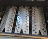 Four metal heat plates are arranged inside a grill. Produktbild-Vorschau