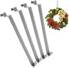 Four gray metal door hooks are shown diagonally on a white background, with a Christmas wreath hanging in the upper right corner. Produktbild-Vorschau
