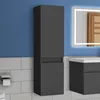 A dark gray bathroom cabinet is mounted on a blue wall above white tiled walls. A toilet paper holder with a roll of toilet paper is visible on the left. Produktbild-Vorschau