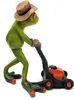 A green frog figurine wearing a straw hat and gloves, pushing a red and black lawnmower. Produktbild-Vorschau
