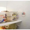 Inside of a refrigerator showing food containers and a thermometer. Podgląd zdjęcia produktu