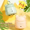 Two cute, bear-shaped mini desktop vacuum cleaners are displayed against a bright, abstract background with cartoonish elements and green leaves. Náhled obrázku produktu