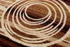 A close-up view of a rug with a swirling pattern. Produktbild-Vorschau