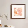 A framed artwork is displayed on a wall above a table with a book and a plant. Anteprima dell’immagine prodotto
