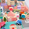 A collection of wooden building blocks forming a miniature town scene, complete with buildings, vehicles, and a play mat. Náhled obrázku produktu