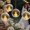 A wedding scene with hanging glass orbs containing LED candles, with a couple in the background. Produktbild-Vorschau