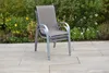 A stacked outdoor chair on a patio with plants in the background. Produktbild-Vorschau