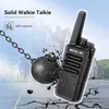 A walkie-talkie is shown with a wrecking ball about to hit it, symbolizing its durability. The background shows a building and a street. Náhľad obrázku produktu