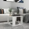 A white side table with books and a vase of greenery on it, placed next to a sofa in a living room. Produktbild-Vorschau