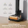 A close-up of a black vacuum cleaner head with internal components highlighted with orange glow, set against a light beige background with feature callouts. Voir les images du produit
