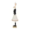 A side profile of a decorative rabbit figurine dressed in a black jacket, white skirt, and black boots, standing on a gold base. Náhľad obrázku produktu