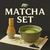 A matcha set with a whisk, bowl, and spoon arranged on a placemat. Produktbild-Vorschau