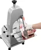 A person wearing white gloves is using a commercial electric meat band saw to cut a large piece of meat. Anteprima dell’immagine prodotto