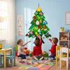 Children decorating a felt Christmas tree in a playroom. Voir les images du produit