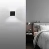 A modern bedroom with a wall-mounted light fixture and a bed. Podgląd zdjęcia produktu