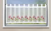 A sheer curtain with a floral pattern is hung on a window.