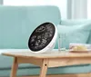 A digital weather station is placed on a wooden table next to a glass of water. Anteprima dell’immagine prodotto