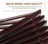 A close-up view of several dark brown wooden hangers stacked on top of each other. Produktbild-Vorschau