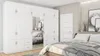 A bedroom scene with a large white modular wardrobe and a bed. Podgląd zdjęcia produktu