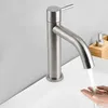 A close-up shot of a modern brushed nickel faucet with water running into a person's hands over a white sink. A soap dispenser is visible in the background. Produktbild-Vorschau