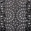A close-up view of a black decorative metal grate with a floral or sunburst pattern. Podgląd zdjęcia produktu