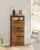 A vintage-style shoe cabinet with three flip-out drawers is placed against a white wall next to a window. A lamp and decorative items are on top of the cabinet. Produktbild-Vorschau