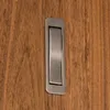 A close-up of a brushed metal pocket door pull handle set into a wooden door. Produktbild-Vorschau