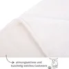 A close-up of a white, fluffy blanket with a folded edge, showing the texture of the material. Text and a goat illustration are present at the bottom. Produktbild-Vorschau