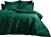 A close-up view of a green quilted bedspread and pillows with a leaf pattern. Voir les images du produit