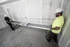 Two construction workers are setting up a long, extendable plank in an unfinished room. Produktbild-Vorschau