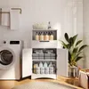 A white bathroom cabinet filled with towels and cleaning supplies, next to a washing machine. Náhled obrázku produktu