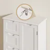 A close-up view of the top of a white cabinet, with an inset circle highlighting a metal bracket and screw assembly attached to the wall and the cabinet. Náhled obrázku produktu