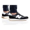 A person's feet wearing New Balance sneakers. Podgląd zdjęcia produktu