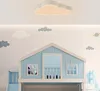 A child's bedroom with a loft bed designed like a house, decorated with cloud and space-themed wall art.